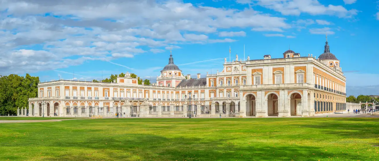 Vista del Palacio Real de Aranjuez con sus jardines históricos y el entorno natural del río Tajo.